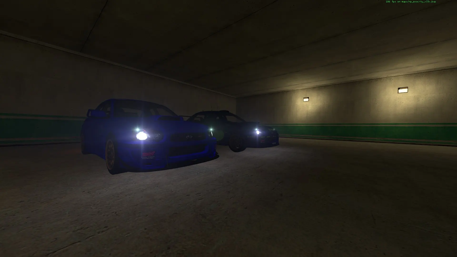 Two tuned cars with headlights on in the EvoCity parking garage